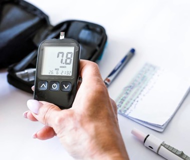 Close-up woman holding a blood glucose meter with normal reading after diabetes test. Home health