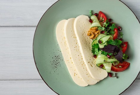 Sliced Imeruli cheese, Georgian cheese, with vegetables, top view, no people