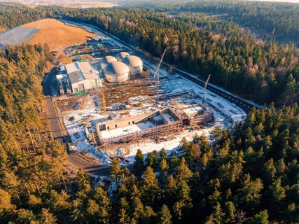 Large construction site next to industrial facilities in the forest, surrounded by snow, new fire