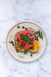 Sandwich with freshly smoked salmon, on black bread, with cottage cheese, with herbs and red