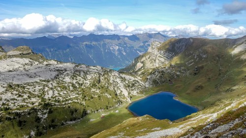 Scenic summer view of a tranquil mountain lake nested in the verdant Alpine ranges, under a clear