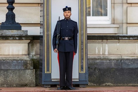 A Queen's Gurkha Signals guardsman stands at attention outside a sentry box at Buckingham Palace,