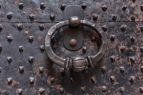 Door knocker on a historic iron door in the old town centre, Genoa, Italy