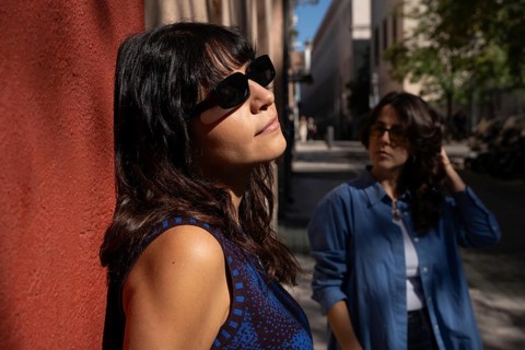 A multiethnic lesbian couple enjoying a sunlit urban area, celebrating diversity with pride. Their
