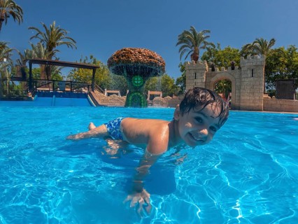 Happy child having fun in a resort water park during summer vacation in alicante, mediterranean sea