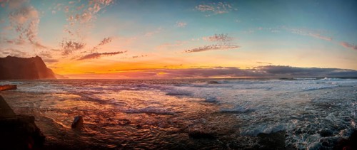 Panorama A romantically colorful sunset over a turbulent sea with a dramatic atmosphere, Ponta do