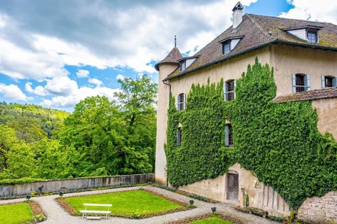 Wildenstein Castle with ivy-covered walls and a well-kept garden against a cloudy sky, Bubendorf,