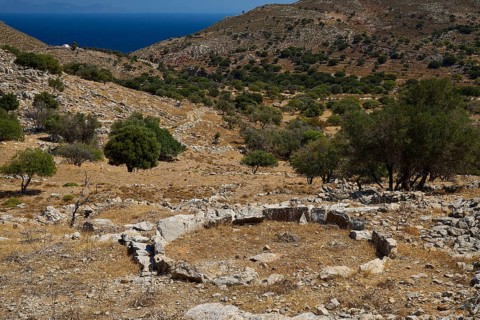 Dry, hilly landscape with ancient ruins and trees, sea view in the background, Lost Place,
