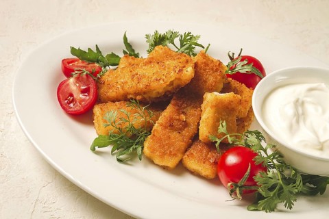 Fried fish nuggets, with white sauce, arugula and cherry, no people