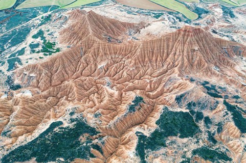 An aerial view captures a stunning barren desert landscape with eroded hills The natural beauty of