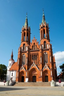 Large, red brick church with two high towers under a clear sky, Church of the Blessed Virgin Mary,
