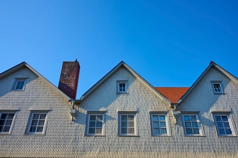 House with white wood paneling, several gables and chimney under clear blue sky, Erbach, Odenwald,