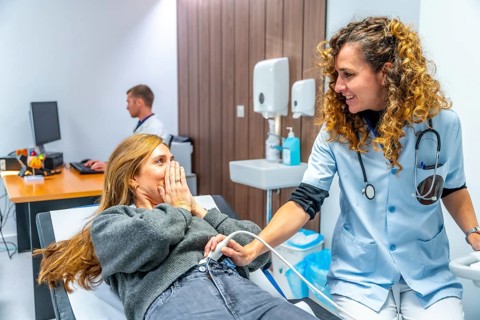 Female doctor informing a patient that she is pregnant during an ultrasound