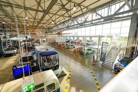 Overview of a large hall with several glass garages and modern cars, Motorworld Böblingen, Germany
