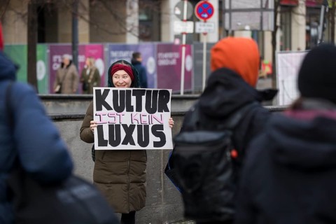 A woman holds a sign Culture is not a luxury at the #unkürzbar! Demonstration against the Berlin
