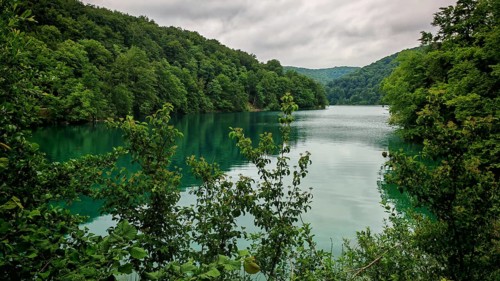 A wide, quiet lake surrounded by green forest, with a relaxed atmosphere, Plitvice Lakes National
