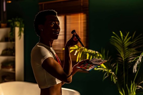 Side view of a latin beauty gay man making up at the evening at home getting ready for a party