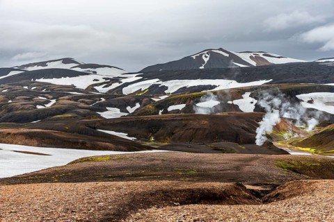 Colourful volcanic landscape with hills and snow, volcanic steaming hot springs, Laugavegur