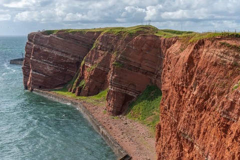 Red coloured sandstone, steep cliff coast of the offshore island of Heligoland, home of the