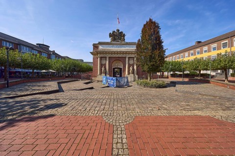 Renovation work on the historic Berliner Tor city gate with street trees and buildings on