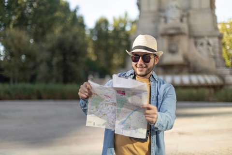 A Latino transgender man wearing a hat and sunglasses enjoys a sunny day out as he explores the