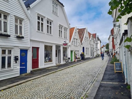 Picturesque street with white wooden houses and cobblestones in a quiet Scandinavian town, Bergen,