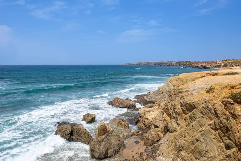 Dramatic cliff landscape with stormy sea and impressive rock formations, Vila Nova de Milfontes,