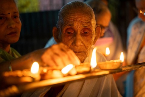 Elderly women of Pramod Talukdar Memorial Old Age Home light Diya oil lamps as they celebrate