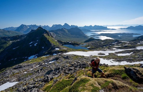 View of mountains and fjord landscape, mountaineers at the summit of Rundfjellet, Austenesfjord and