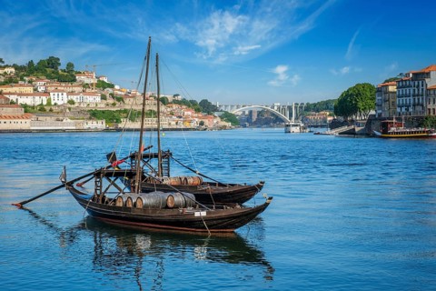 View of Porto city and Douro river with traditional boats with port wine barrels from famous