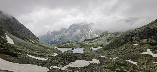Cold, rainy mountain panorama with melting snow and cloudy sky, hiking, Rysy, High Tatras, Slovakia