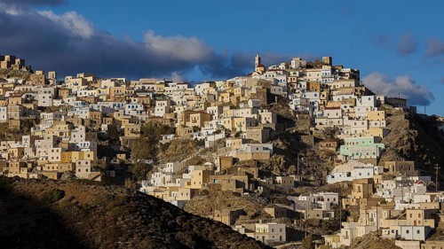 Densely built-up area on mountain slopes in the morning light with a striking church tower in the
