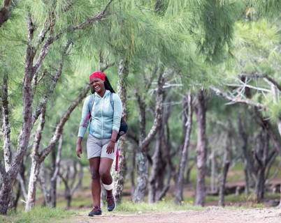 Mauritian woman, 35 years old, laughing, walking through a casuarina forest, Rodrigues Island,