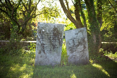 Tombstones, graves, trees, flooded with light, cemetery, parish church, St Just in Penwith,