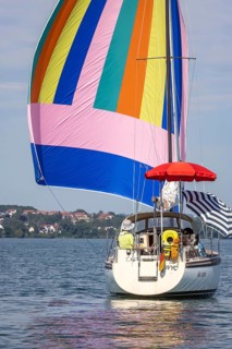 Sailing party on Lake Constance, yacht with colourful foresail and sunshades, Immenstaad,