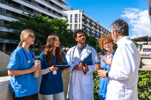 Diverse team of doctors and nurses collaborating during a casual outdoor meeting, exchanging ideas