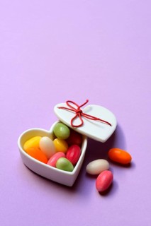 Colourful sugar eggs in a heart-shaped ceramic bowl, Easter eggs, sugar Easter eggs