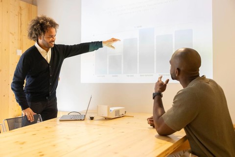 Two professionals engage in a collaborative business presentation at a modern coworking space in
