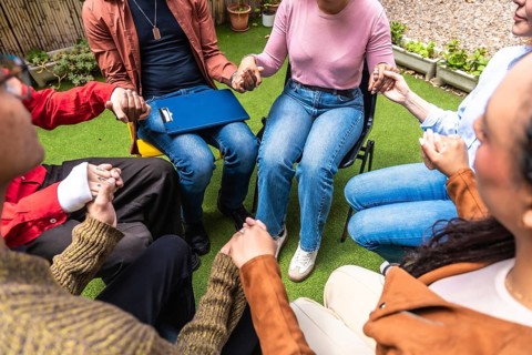 People forming a circle, holding hands, and sharing moments of connection and solidarity during a