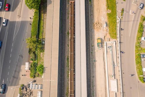 Aerial view of a railway system with rails and roads running next to them, construction site by
