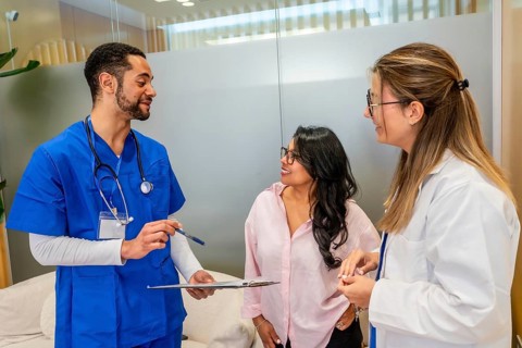 Patient consulting with a multi ethnic healthcare team members, a male nurse or doctor presenting