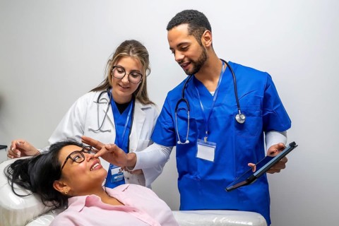Medical professionals consulting a patient during a healthcare check up, with one doctor pointing