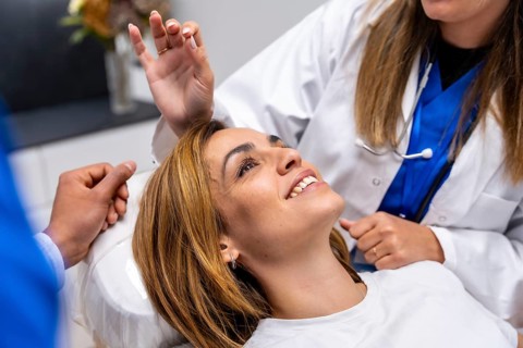 Patient smiling confidently while a doctor performs a medical examination, symbolizing trust,
