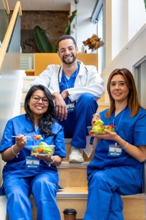 Three diverse healthcare professionals in scrubsdoctor and nursessitting on hospital stairs,
