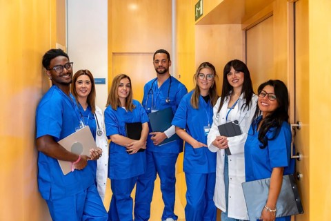 Group of smiling healthcare professionals of various ethnicities and genders posing together in a