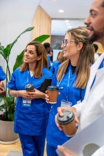 Group of diverse medical professionals, including doctors and nurses, wearing scrubs and white