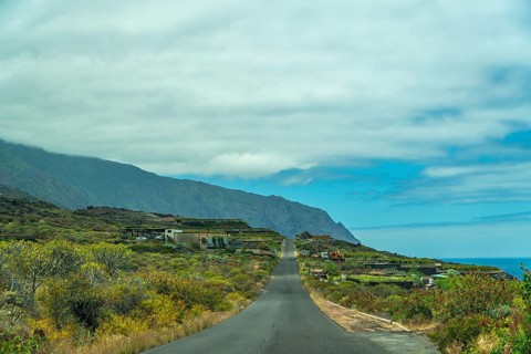 Winding asphalt road navigating through the lush volcanic landscape of el hierro island, with