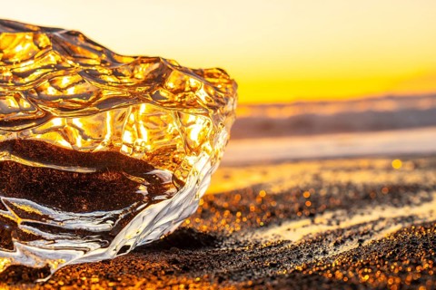 Clear ice at sunrise on Diamond Beach next to Jokulsarlon in winter in Iceland