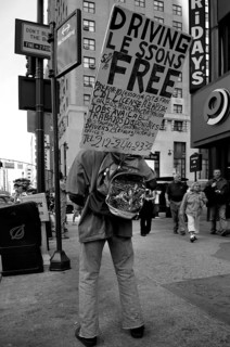 Man carrying an advertising sign for a driving school, New York City, USA