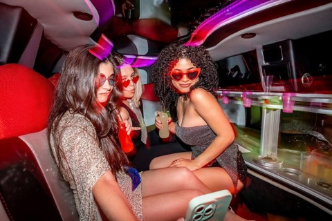 Three young women wearing heart shaped sunglasses and glamorous outfits are having a private